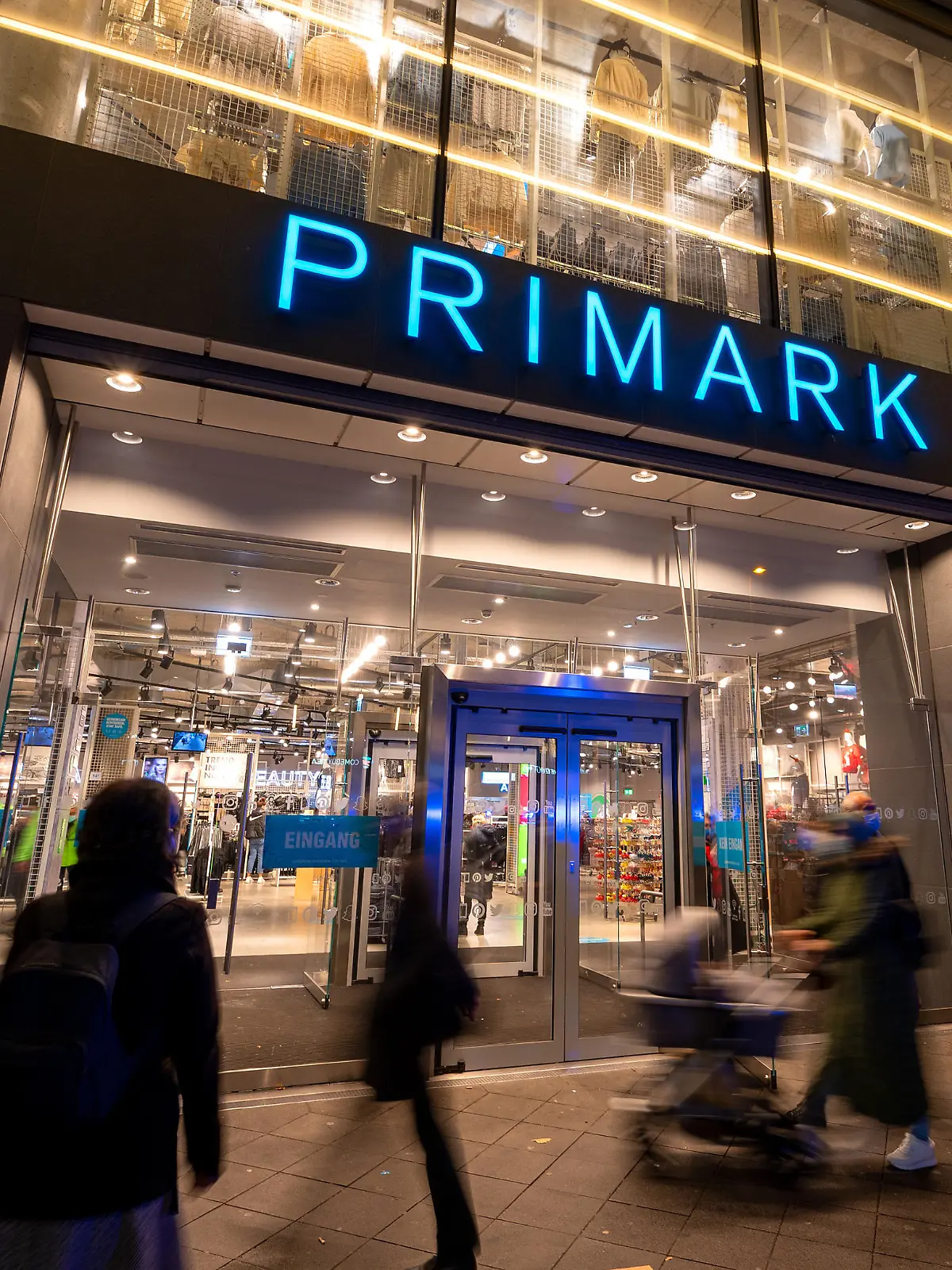 Passanten gehen am Abend an dem Bekleidungsgeschäft Primark vorbei.