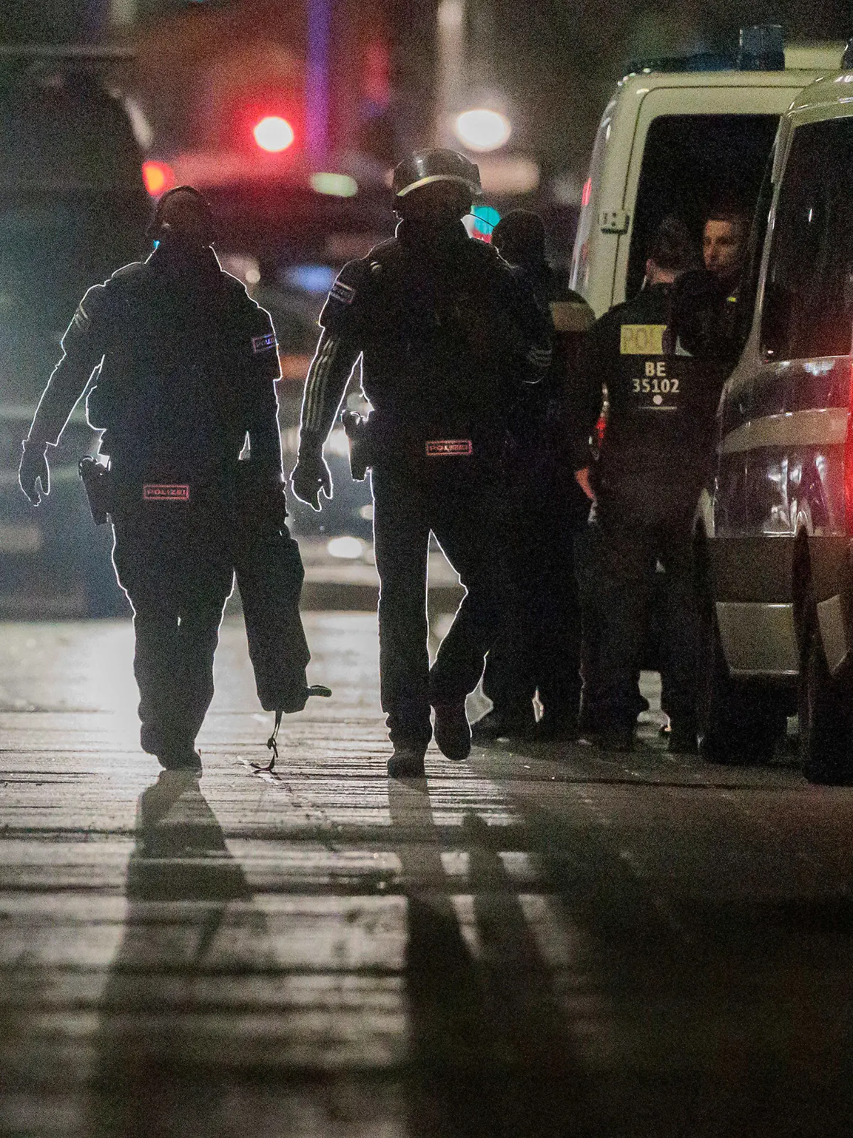 25.04.2023, Berlin: Polizisten gehen zu den Einsatzfahrzeugen nach der Beendigung einer Geiselnahme in einem Geschäft an der Keithstraße. Dort war es zu einem Überfall auf ein Geschäft gekommen, bei dem auch eine Geisel genommen wurde. Foto: Carsten Koall/dpa +++ dpa-Bildfunk +++