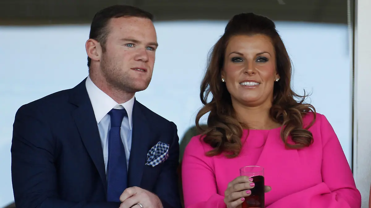 LIVERPOOL, ENGLAND - APRIL 12:  Manchester United football player Wayne Rooney and his wife Coleen watch the racing during the first day of the Aintree Grand National meeting on April 12, 2012 in Aintree, England. The first day, known as Liverpool Day, celebrates the city's link with the famous Aintree Racecourse.  (Photo by Christopher Furlong/Getty Images)