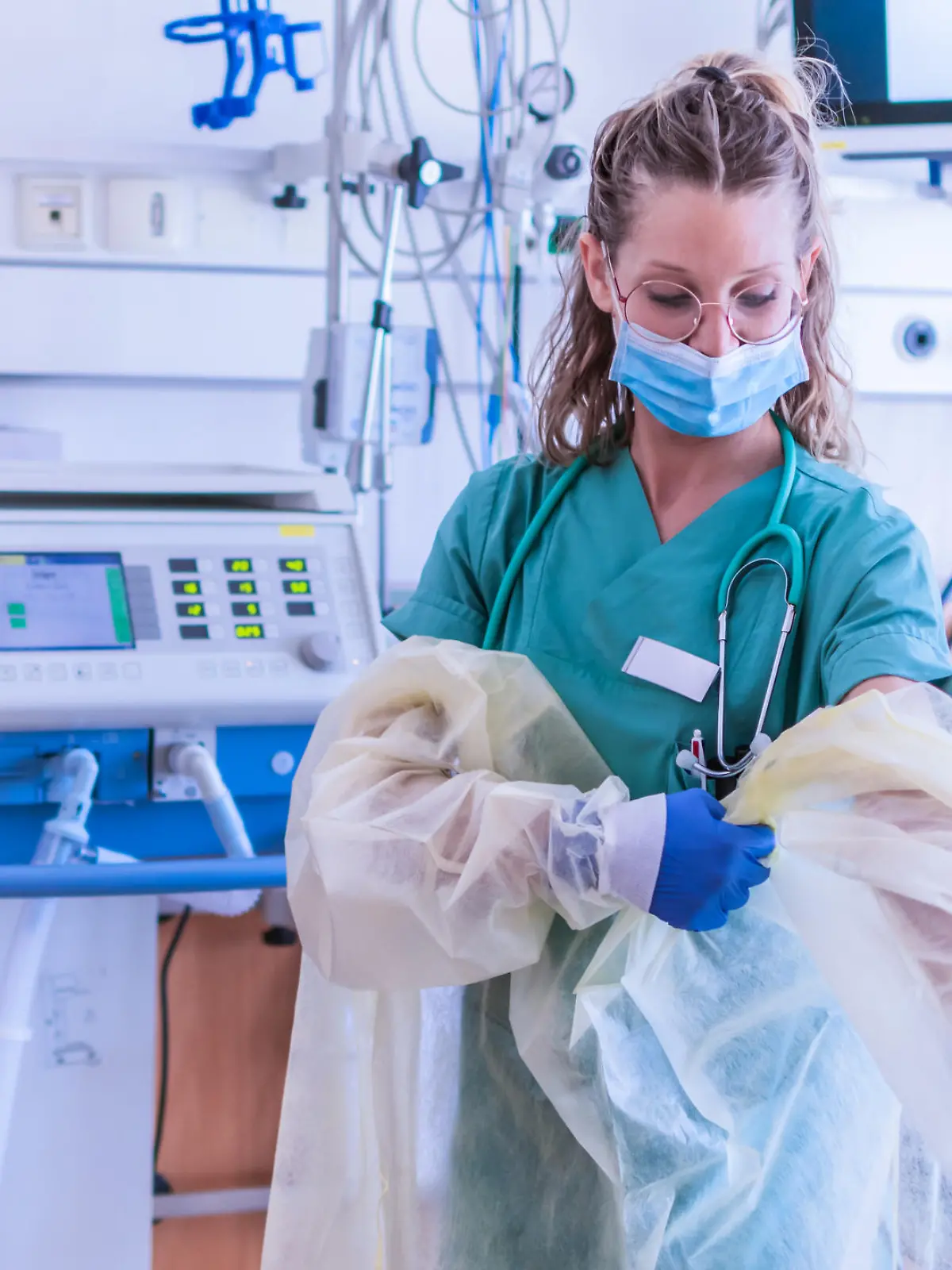 Krankenhausmitarbeiterin zieht sich Schutzkleidung an