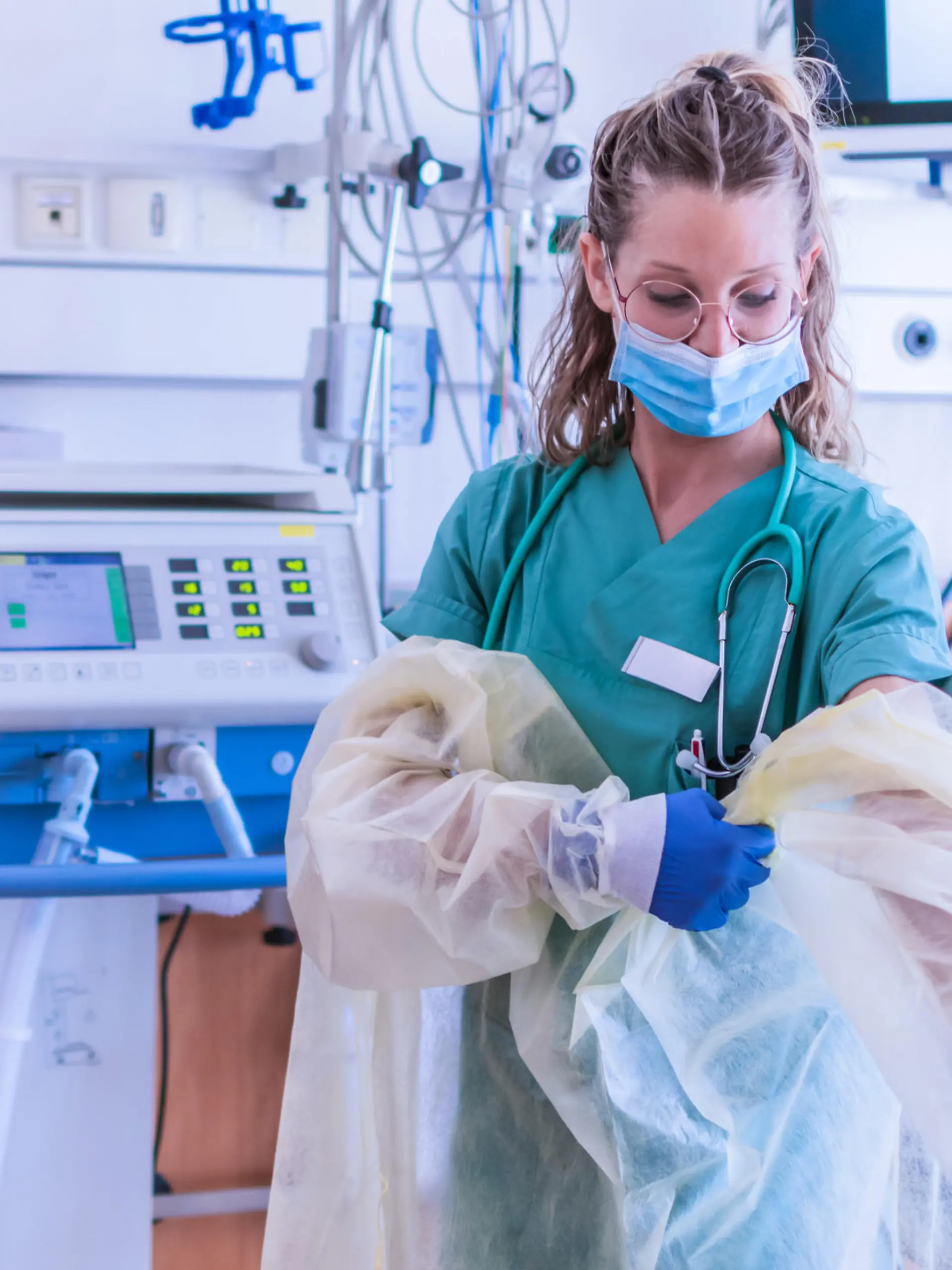Krankenhausmitarbeiterin zieht sich Schutzkleidung an