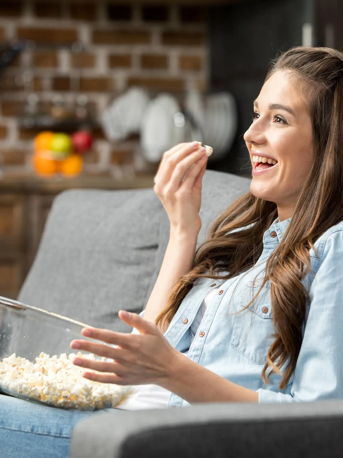 Junge Frau lacht über das TV-Programm