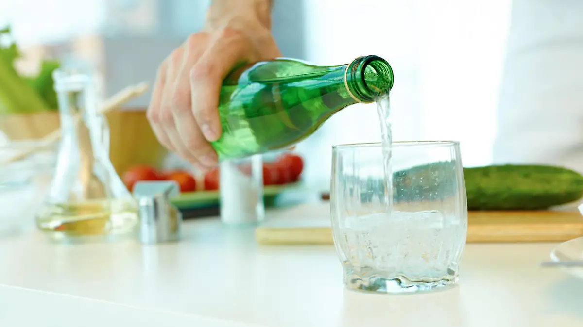 Frau gießt Mineralwasser ein