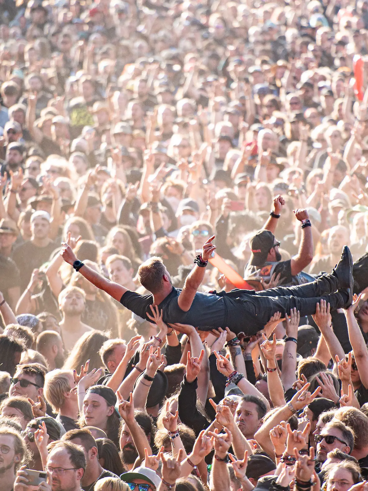 ARCHIV - 06.08.2022, Schleswig-Holstein, Wacken: Festivalbesucher werden beim Wacken Open Air Festival beim Crowdsurfen über die Menge getragen. Das WOA gilt als größtes Heavy-Metal-Festival der Welt. (zu dpa: Festivalsaison 2023: Die Personaldecke hält, aber die Kosten steigen) Foto: Daniel Reinhardt/dpa +++ dpa-Bildfunk +++