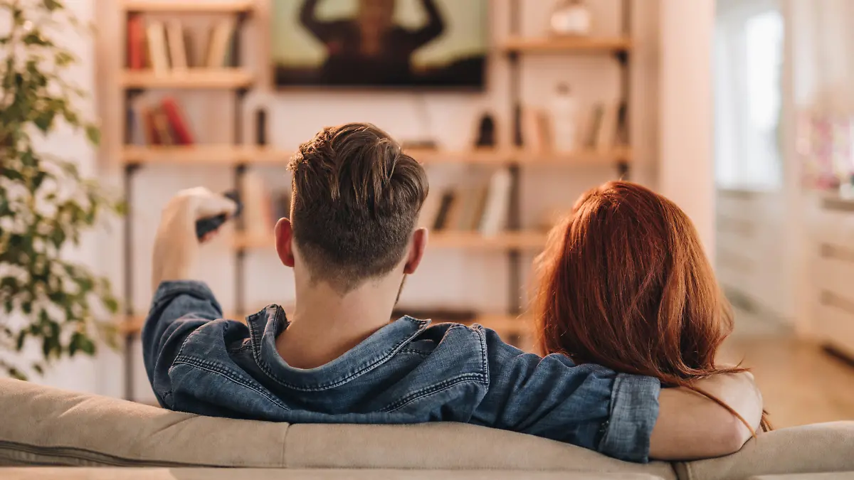 Paar sitzt vor dem Fernseher.