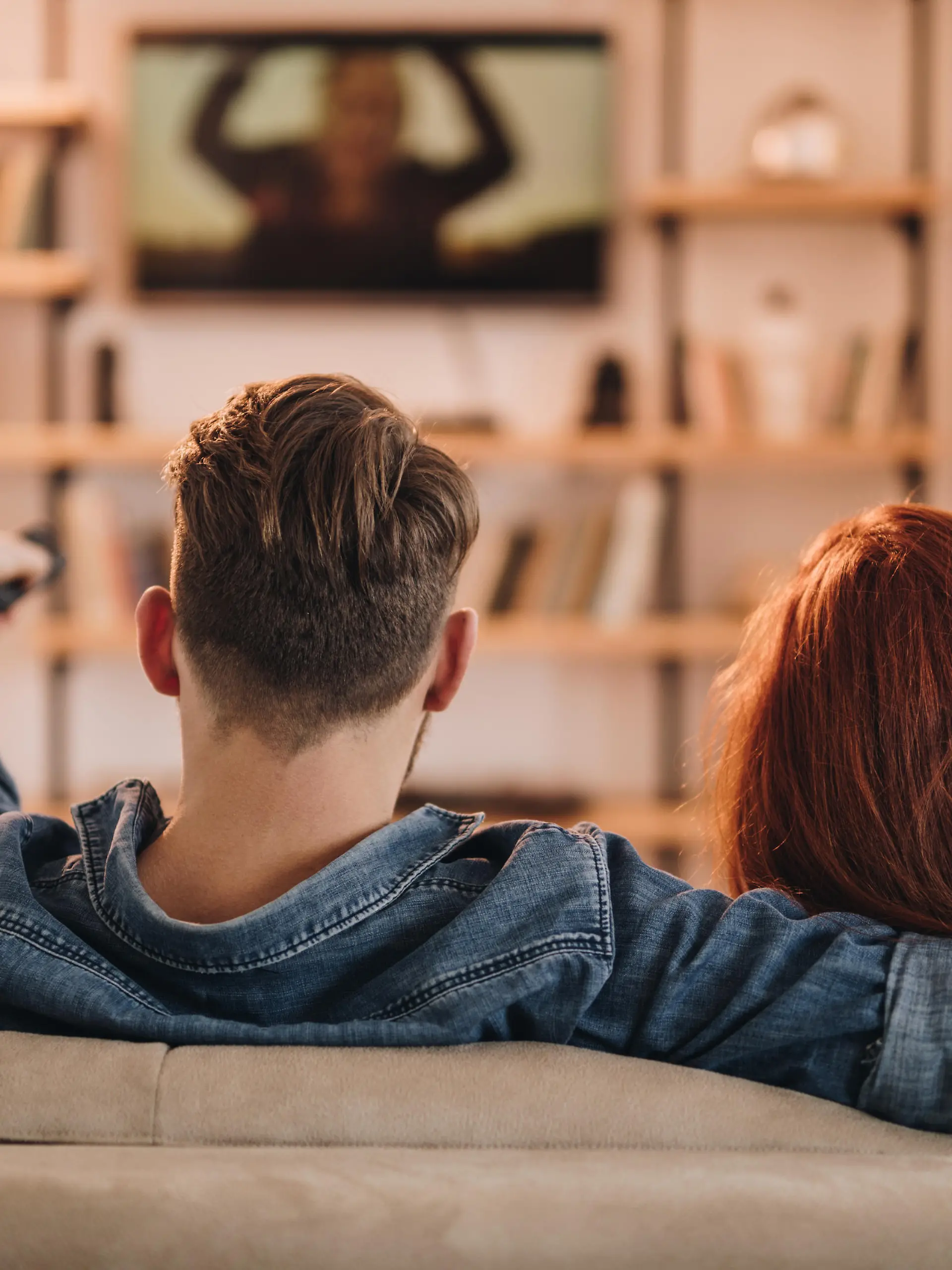 Paar sitzt vor dem Fernseher.