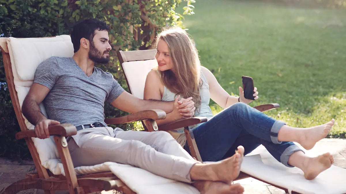 Mann und Frau entspannen auf Gartenmöbel von Aldi.