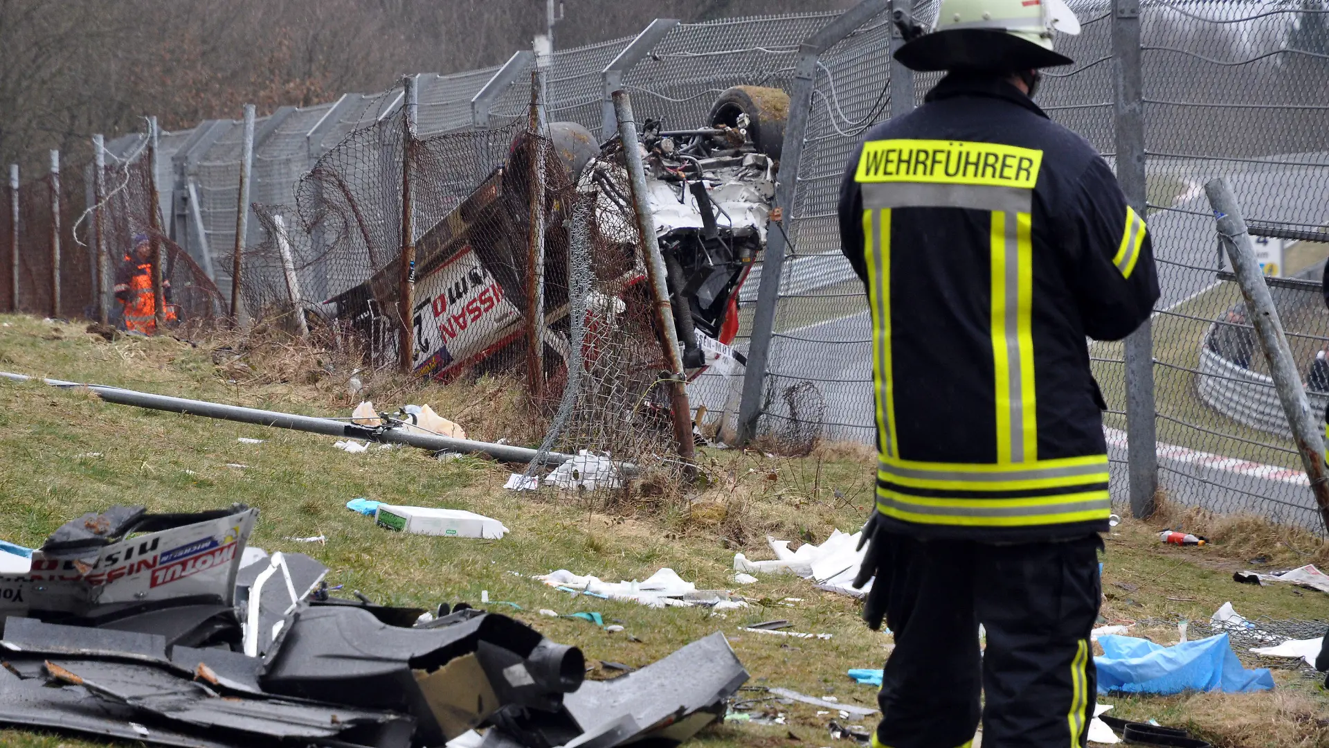Der Nissan des britischen Fahrers Jann Mardenborough liegt am 28.03.2015 im Bereich «Flughafen» der Nordschleife neben der Strecke am Nürburgring in Nürburg (Rheinland-Pfalz). Mardenborough war bei der VLN Langstreckenmeisterschaft auf dem Nürburgring von der Strecke abgekommen und in den Zuschauerbereich geflogen, dabei starb ein Zuschauer. Foto: Andreas Winkler/dpa +++(c) dpa - Bildfunk+++