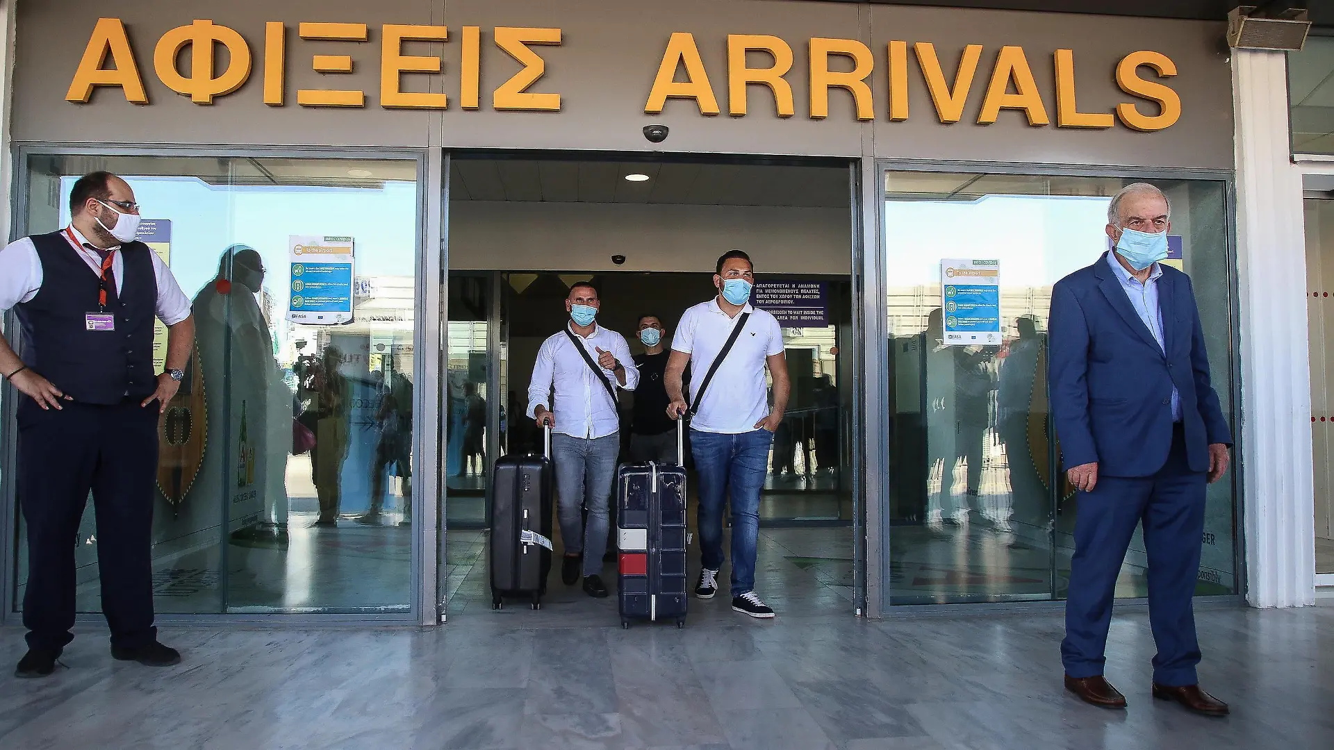 01.07.2020, Griechenland, Iraklion: Touristen mit medizinischem Mundschutz kommen am internationalen Flughafen der griechischen Insel Kreta an. Landesweit wurden alle Flughäfen für Auslandsflüge geöffnet. Erstmals nach Ausbruch der Corona-Pandemie sind Charterflugzeuge aus Deutschland auf dem Flughafen von Kreta gelandet und wurden feierlich mit Musikanten und den lokalen Schnaps Tsikoudiá empfangen. Foto: Eurokinissi/Eurokinissi via ZUMA Wire/dpa +++ dpa-Bildfunk +++
