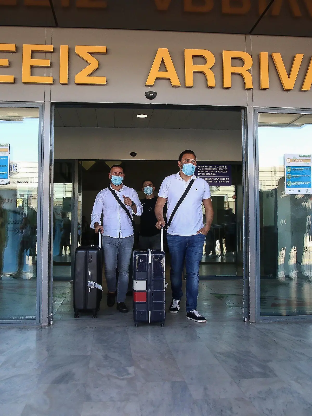 01.07.2020, Griechenland, Iraklion: Touristen mit medizinischem Mundschutz kommen am internationalen Flughafen der griechischen Insel Kreta an. Landesweit wurden alle Flughäfen für Auslandsflüge geöffnet. Erstmals nach Ausbruch der Corona-Pandemie sind Charterflugzeuge aus Deutschland auf dem Flughafen von Kreta gelandet und wurden feierlich mit Musikanten und den lokalen Schnaps Tsikoudiá empfangen. Foto: Eurokinissi/Eurokinissi via ZUMA Wire/dpa +++ dpa-Bildfunk +++