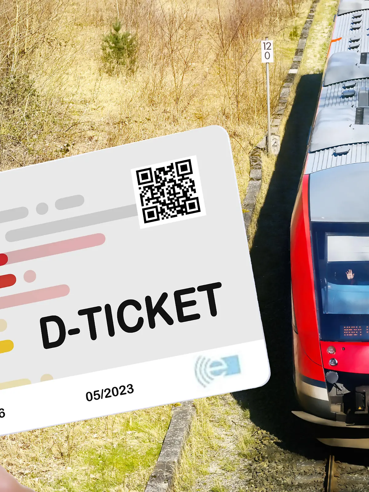 Hand hält das Deutschlandticket D-Ticket vor einer Regionalbahn / action press