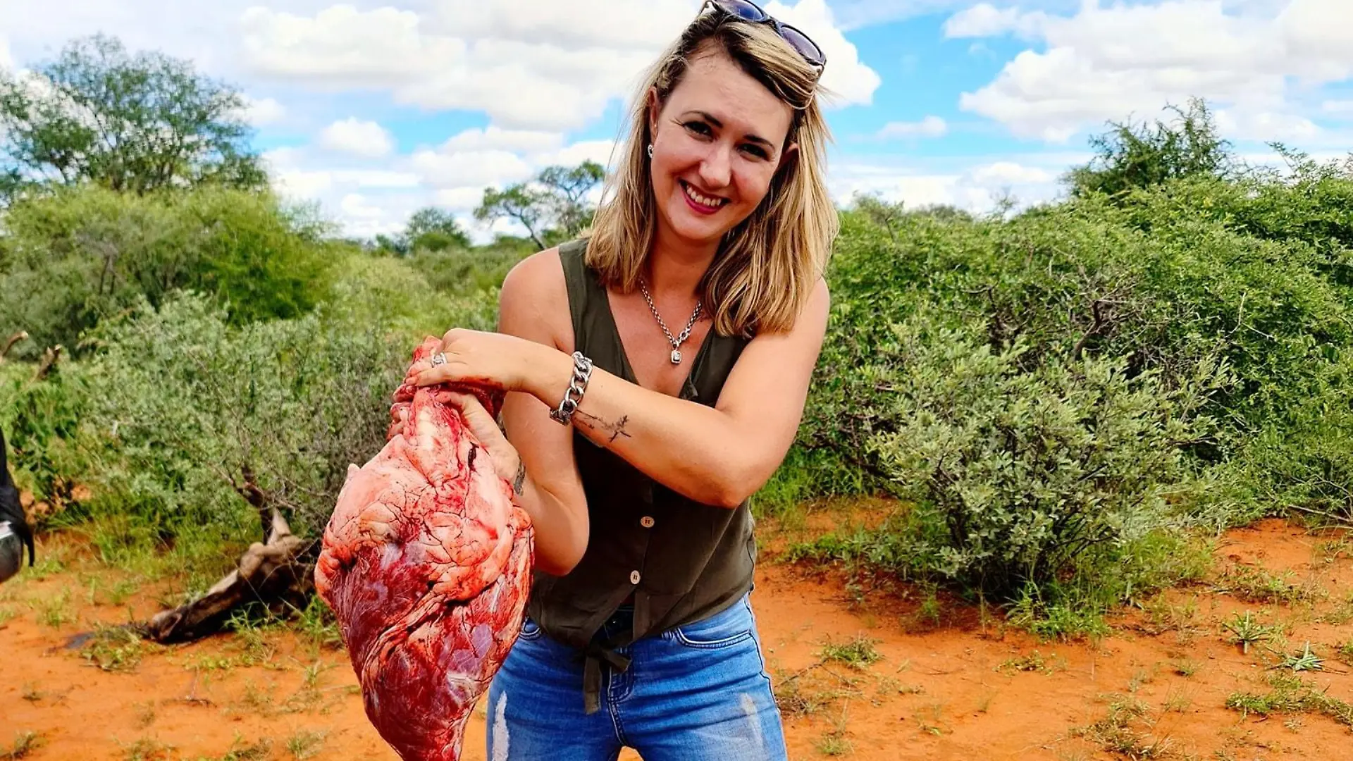 Merelize van der Merwe aus Südafrika posiert stolz mit dem Herz einer Giraffe, die sie gerade erschossen hat.