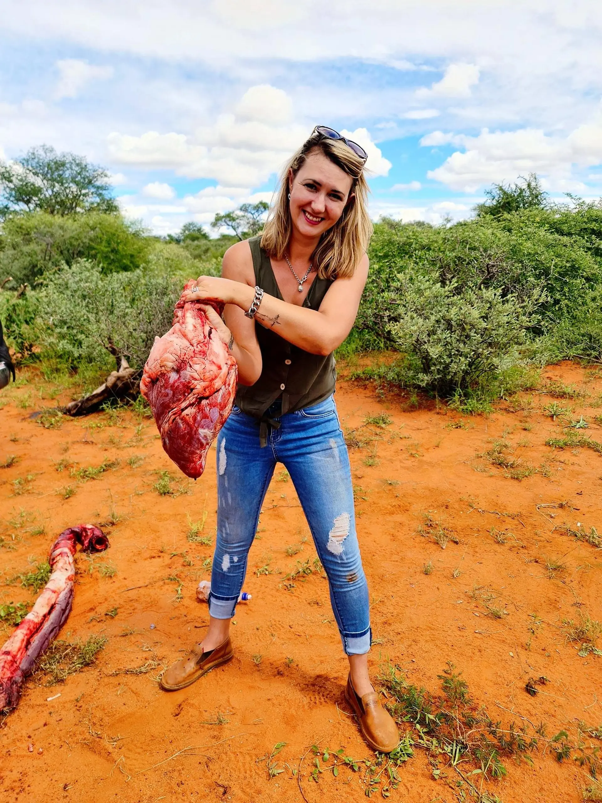 Merelize van der Merwe aus Südafrika posiert stolz mit dem Herz einer Giraffe, die sie gerade erschossen hat.