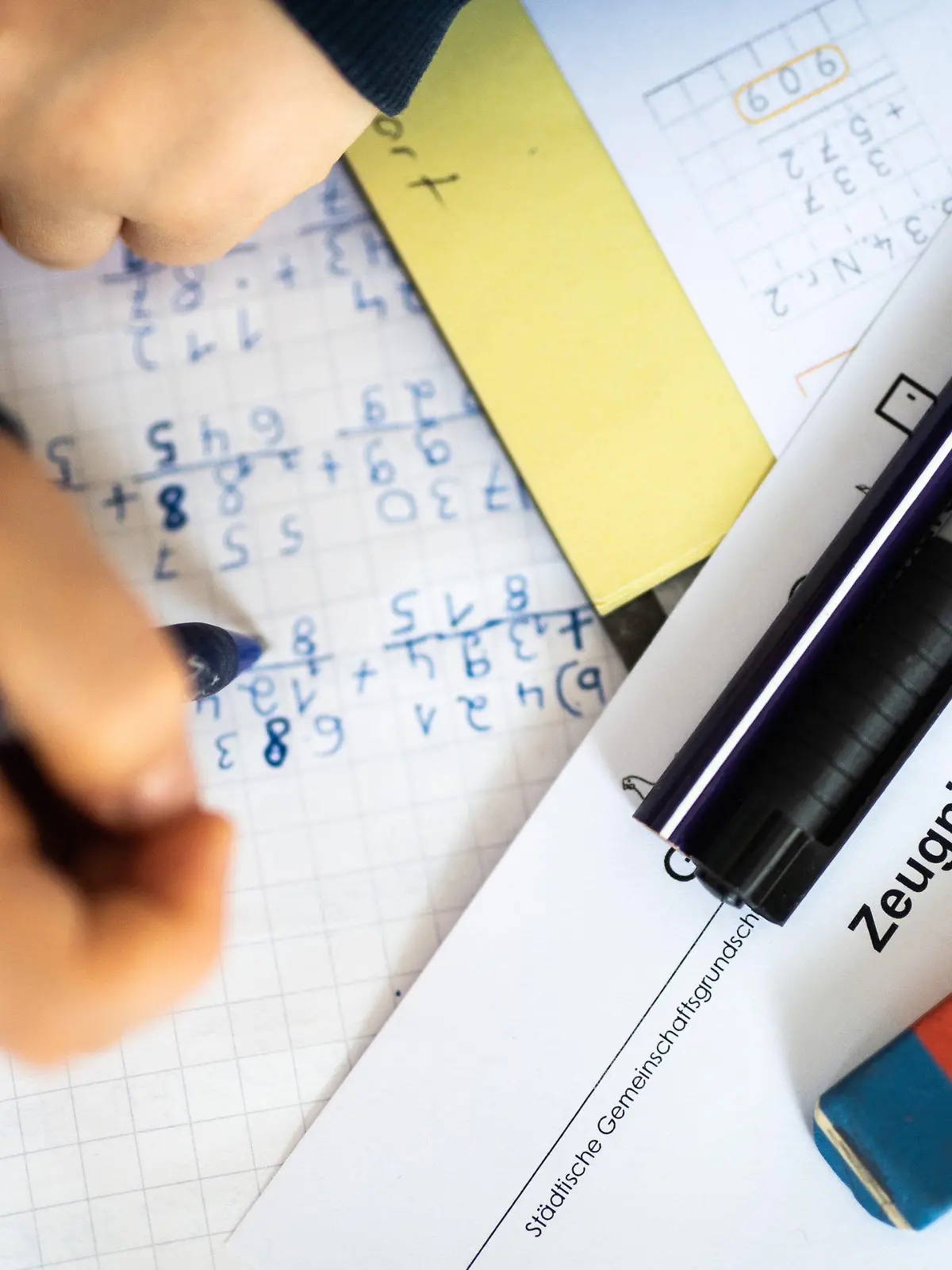 29.01.2021, Nordrhein-Westfalen, Wetter: ILLUSTRATION - Eine Schülerin der dritten Klasse arbeitet an ihrem Schreibtisch, während ihr Zeugnis auf ihrem Schreibtisch liegt. (gestellte Szene) Mitten im coronabedingten Distanzunterricht erhalten 2,5 Millionen Schüler in Nordrhein-Westfalen ihre Halbjahreszeugnisse. Foto: Jonas Güttler/dpa +++ dpa-Bildfunk +++