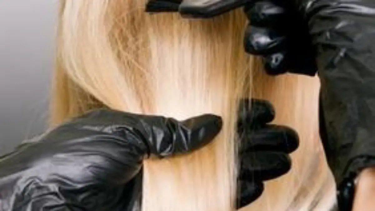 hairdresser doing hair dye. photo against grey background