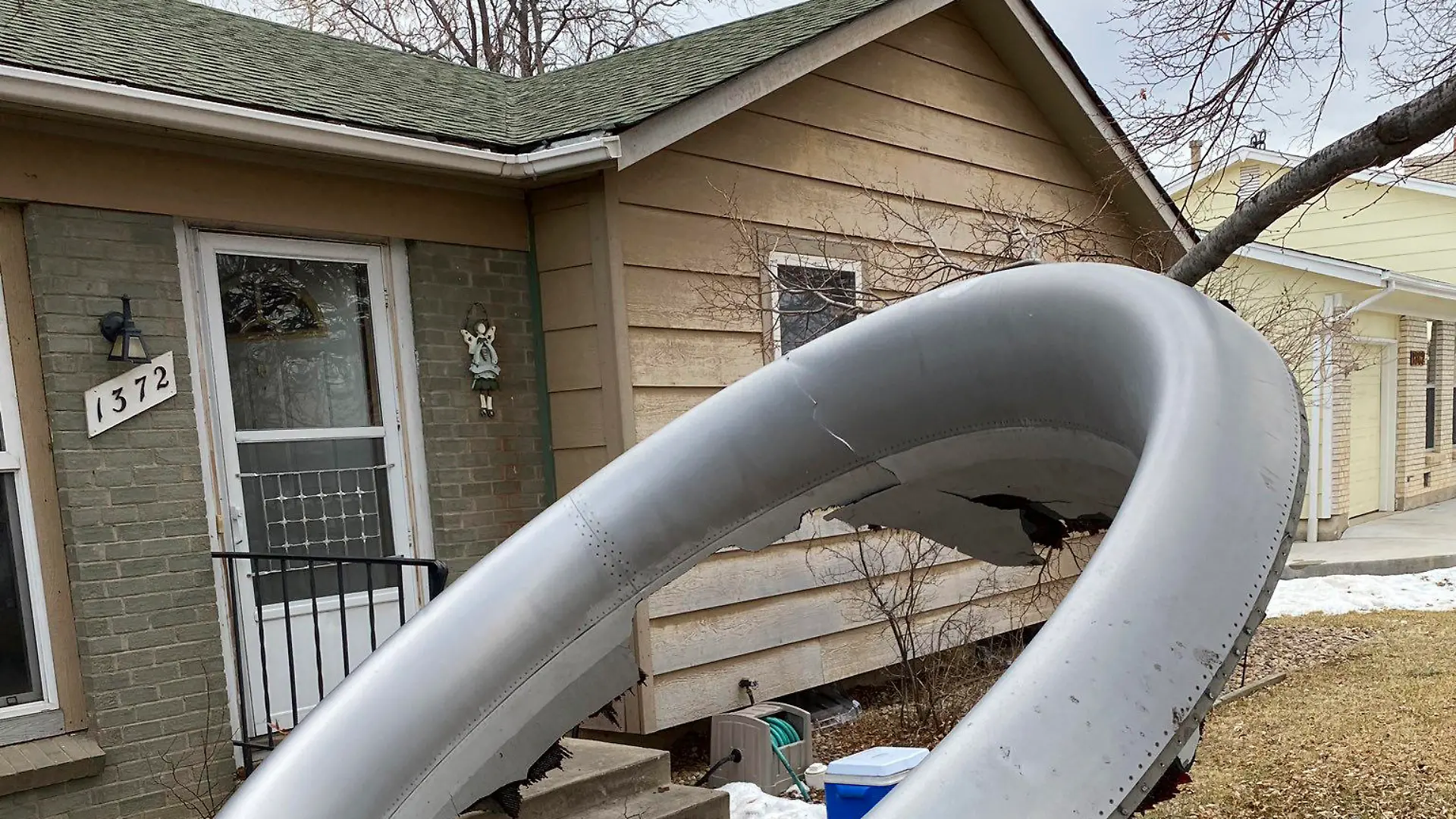HANDOUT - 20.02.2021, USA, Broomfield: Das vom der Polizei Broomfield über Twitter veröffentlichte Foto zeigt ein großes Bauteil eines Flugzeugtriebwerks in einem Vorgarten eines Hauses. Teile eines Flugzeugs sind nach Angaben der Polizei unweit von der US-Stadt Denver im Bundesstaat Colorado in mehrere Wohngebiete gestürzt. (zu dpa «USA: Flugzeug verliert Teile über Wohngebieten bei Denver») Foto: -/Broomfield Police Department/AP/dpa +++ dpa-Bildfunk +++
