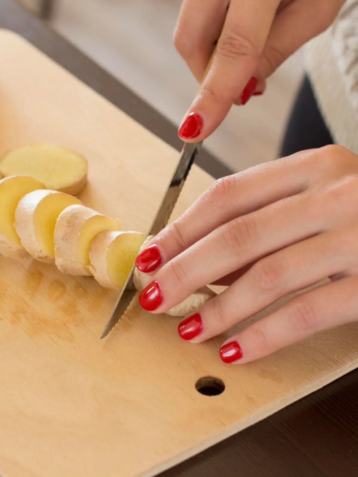 sliced ginger root on a wooden cutting board
