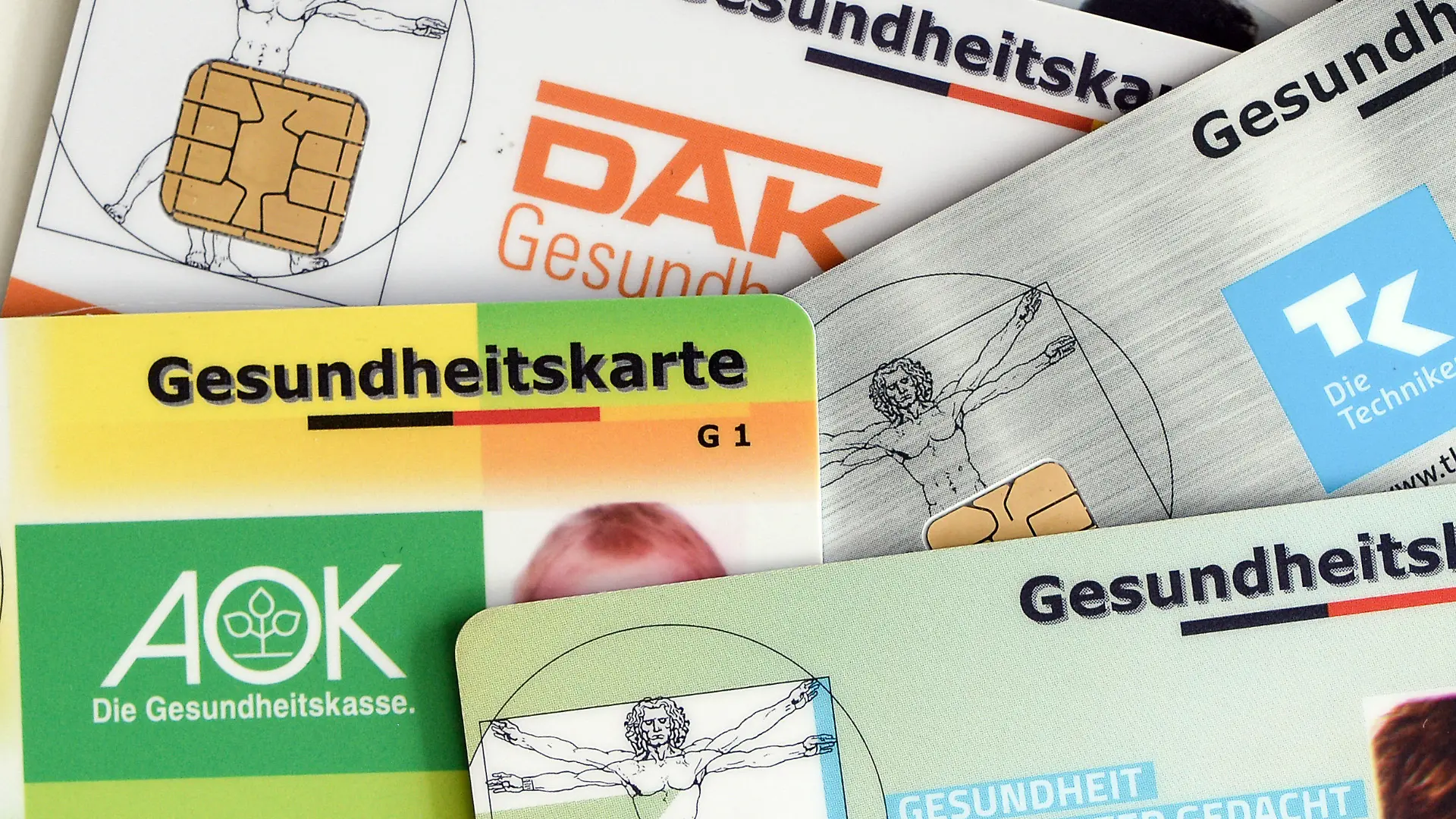 ARCHIV - 17.04.2018, Berlin: Gesundheitskarten verschiedener Krankenkassen liegen auf einem Tisch. Die Mitglieder der gesetzlichen Krankenkassen sollen dauerhaft davor geschützt werden, steigende Gesundheitskosten allein tragen zu müssen. Foto: Jens Kalaene/dpa-Zentralbild/dpa +++ dpa-Bildfunk +++