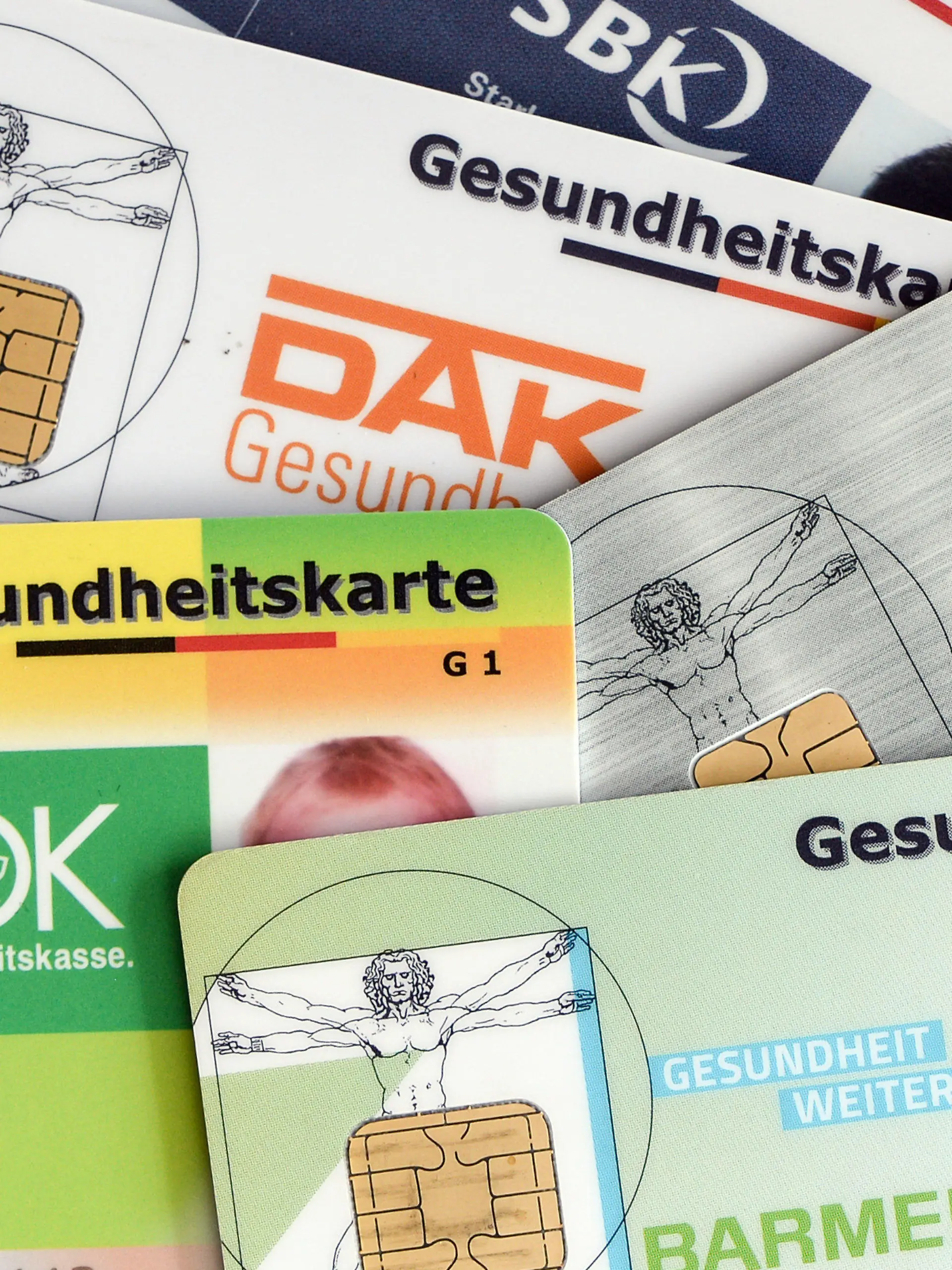 ARCHIV - 17.04.2018, Berlin: Gesundheitskarten verschiedener Krankenkassen liegen auf einem Tisch. Die Mitglieder der gesetzlichen Krankenkassen sollen dauerhaft davor geschützt werden, steigende Gesundheitskosten allein tragen zu müssen. Foto: Jens Kalaene/dpa-Zentralbild/dpa +++ dpa-Bildfunk +++