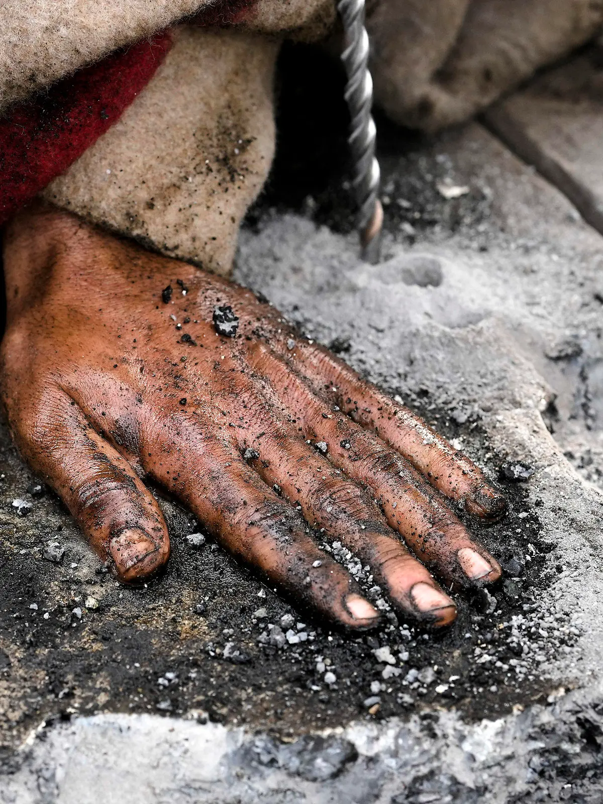 Police remove the pavement next to the hand of a climate activist during a protest against the climate policy of the German government in Berlin, Germany, Monday, April 24, 2023. German climate activists tried bringing traffic to a standstill in Berlin on Monday morning by gluing themselves to streets all over the capital. (AP Photo/Markus Schreiber)