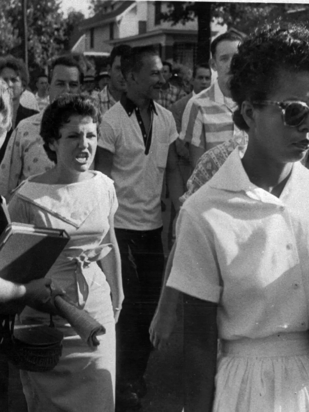 In this Sept. 4, 1957 file photo, students of Central High School in Little Rock, including Hazel Bryan, shout insults at Elizabeth Eckford as she calmly marches down to a line of National Guardsmen