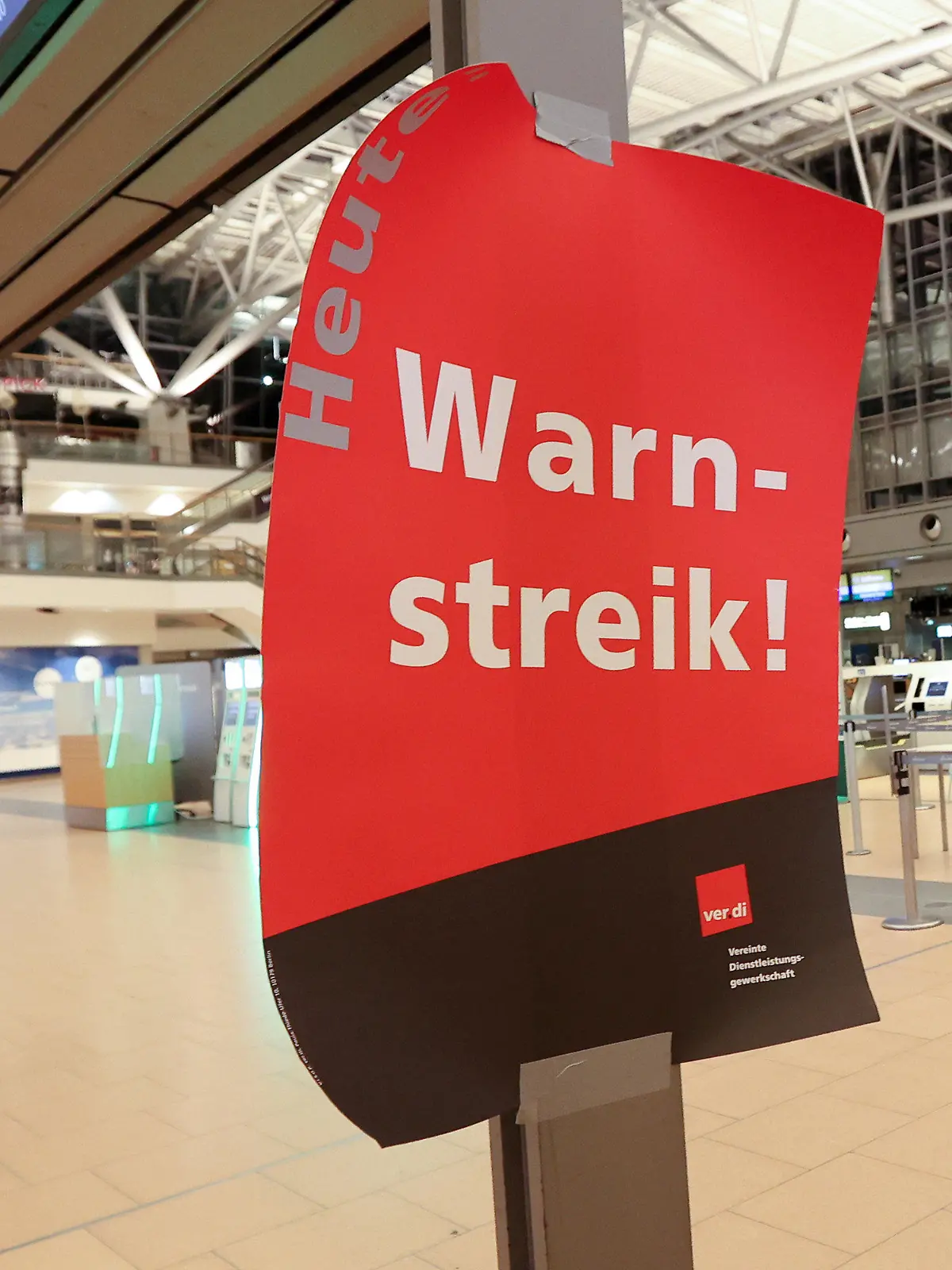 22.03.2023, Hamburg: Ein Plakat mit dem Text ·Warnstreik· hängt im menschenleeren Terminal 2 im Flughafen Hamburg. Am Flughafen Hamburg hat ein weiterer Warnstreik der Gewerkschaft verdi am Mittwoch, 22. März, um 22:00 Uhr begonnen. Foto: Bodo Marks/dpa +++ dpa-Bildfunk +++