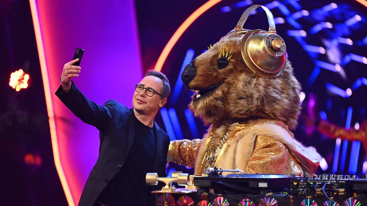HANDOUT - 16.02.2021, Nordrhein-Westfalen, Köln: Moderator Matthias Opdenhövel macht ein Selfie mit der Figur "Quokka" in der ersten Folge der vierten Staffel der ProSieben-Show «The Masked Singer». Bei «The Masked Singer» singen Prominente in aufwendigen Bühnenkostümen um die Wette. Foto: Willi Weber/ProSieben/dpa - ACHTUNG: Nur zur redaktionellen Verwendung im Zusammenhang mit einer Berichterstattung über die Sendung und nur mit vollständiger Nennung des vorstehenden Credits. Das Foto darf nicht verändert und nur im vollen Ausschnitt verwendet werden. Keine Archivierung +++ dpa-Bildfunk +++