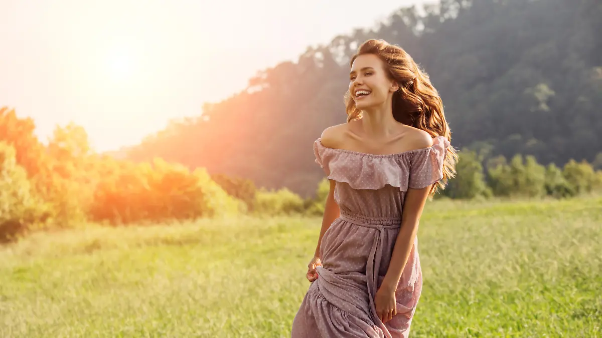 Beautiful happy girl walking by the field