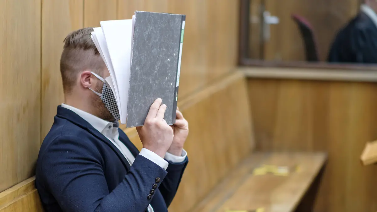 ARCHIV - 03.07.2020, Niedersachsen, Hannover: Im Prozess um den Mord an einer jungen Frau hält sich der Angeklagte im Landgericht Hannover zu Prozessbeginn einen Aktenordner vor das Gesicht. Der Mann soll eine 23-Jährige gestalkt und in ihrem Badezimmer mit einem Klappmesser erstochen haben. (zu dpa: «Dem Angeklagten tut es «unendlich leid»: 23-Jährige erstochen») Foto: Ole Spata/dpa +++ dpa-Bildfunk +++