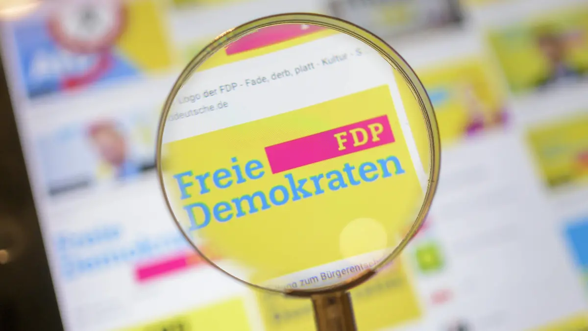 FDP Logo, Politik, Symbolbild, FDP Partei Logo durch eine Lupe angesehen. *** FDP logo, politics, symbol image, FDP party logo viewed through a magnifying glass