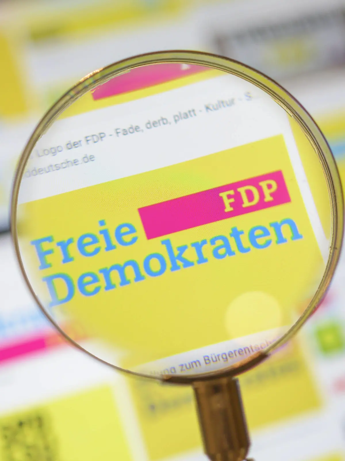  FDP Logo, Politik, Symbolbild, FDP Partei Logo durch eine Lupe angesehen. *** FDP logo, politics, symbol image, FDP party logo viewed through a magnifying glass