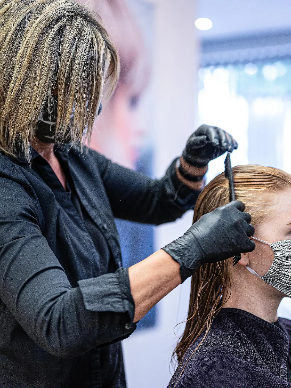 Friseurin kämmt Kundin