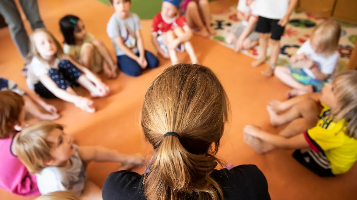 Erzieherin sitzt mit Kindern im Kindergarten im Kreis auf dem Boden, Köln, Nordrhein-Westfalen, Deutschland, Europa *** Educator sits with children in the kindergarten in a circle on the floor, Cologne, North Rhine-Westphalia, Germany, Europe Copyright: imageBROKER/JanxTepass ibxjte05109368.jpg Bitte beachten Sie die gesetzlichen Bestimmungen des deutschen Urheberrechtes hinsichtlich der Namensnennung des Fotografen im direkten Umfeld der Veröffentlichung!