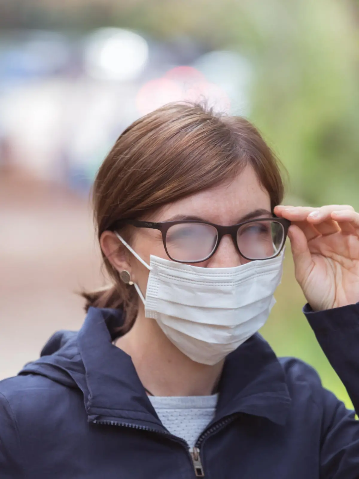 Frau mit beschlagener Brille und Mund-Nasen-Maske