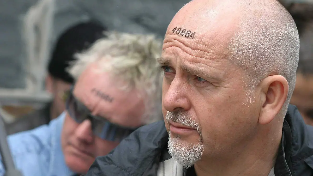 Peter Gabriel in Südafrika, auf seiner Stirn die Häftlingsnummer von Nelson Mandela.