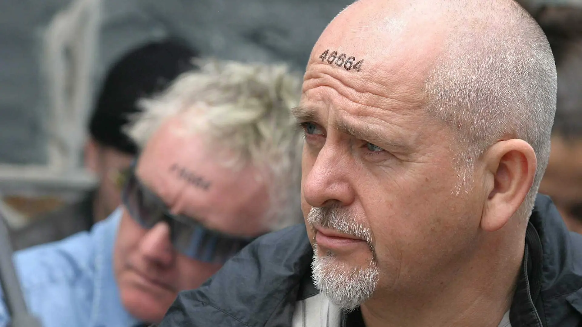 Peter Gabriel in Südafrika, auf seiner Stirn die Häftlingsnummer von Nelson Mandela.