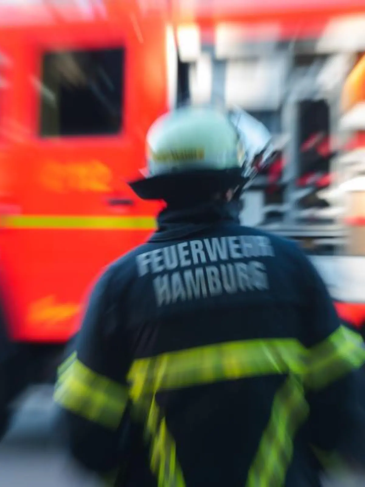 Feuerwehrmann steht vor einem Löschfahrzeug