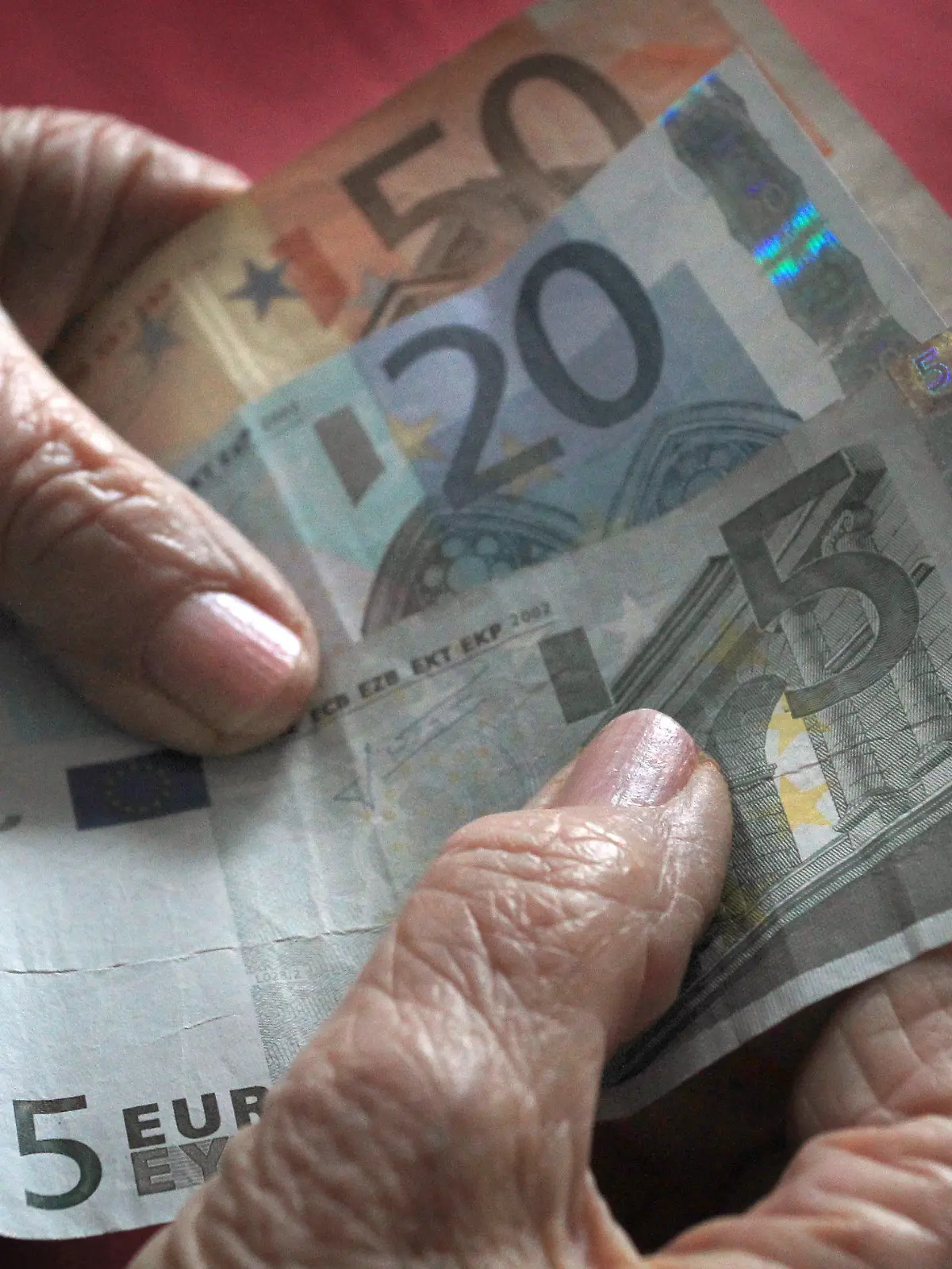 ARCHIV - 17.03.2013, Bayern, Würzburg: Eine 83-jährige Frau hält verschiedene Euronoten in der hand. Die Menschen in Deutschland beziehen immer länger Rente, zugleich sind sie in den vergangenen Jahren immer später in Rente gegangen. Foto: Karl-Josef Hildenbrand/dpa +++ dpa-Bildfunk +++
