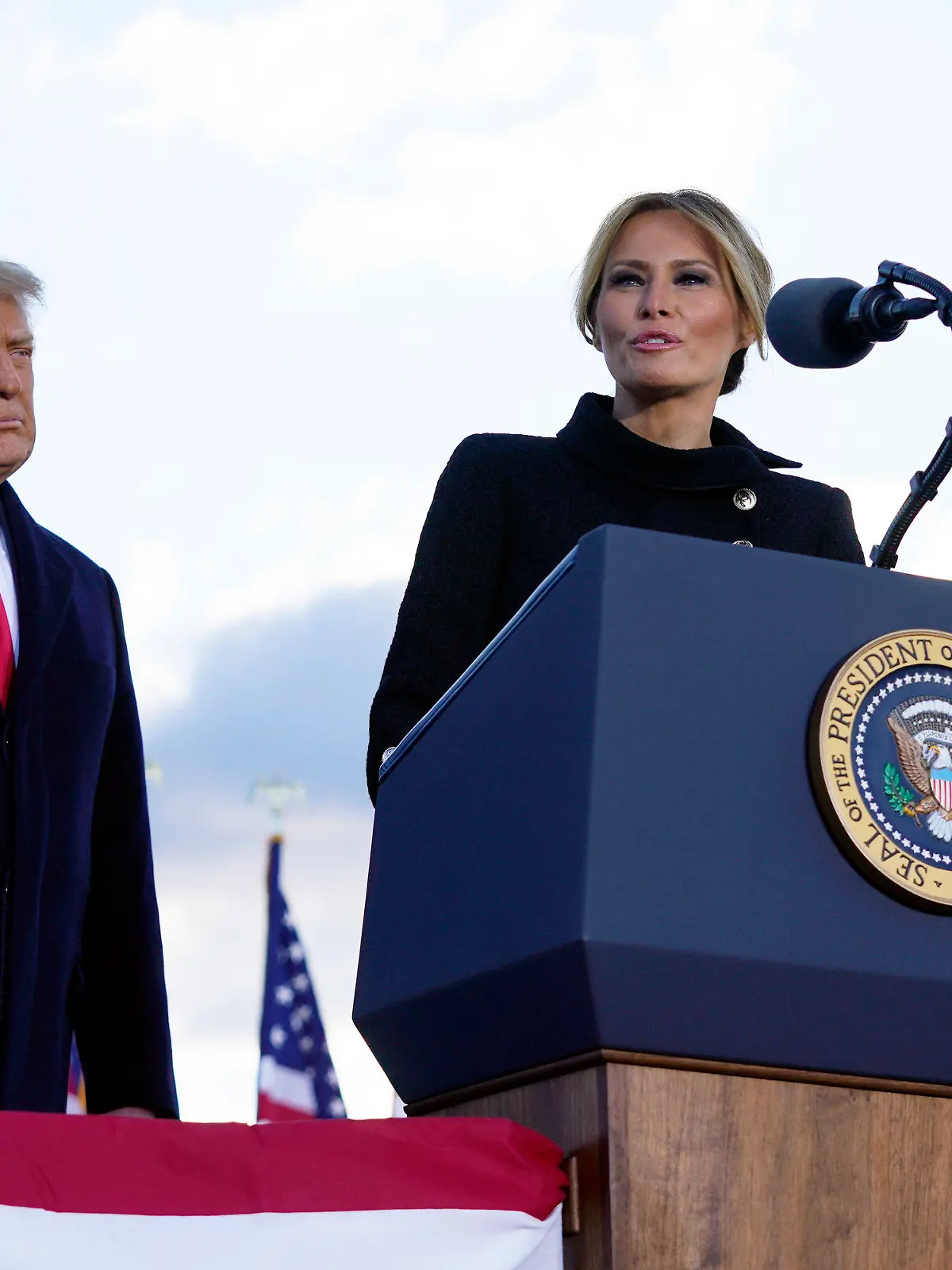 20.01.2021, USA, Andrews Air Force Base: Donald Trump, Präsident der USA, hört zu, während seine Frau Melania Trump, First Lady der USA, auf der Andrews Air Force Base spricht, bevor sie an Bord der Air Force One gehen.  Die Vereidigung von Biden als 46. US-Präsident besiegelt am (heutigen) Mittwoch das Ende der turbulenten Amtszeit von Präsident Trump. Trump wird als erster Präsident seit Johnson im Jahr 1869 der Amtseinführung seines Nachfolgers vor dem Kapitol in Washington fernbleiben. Foto: Manuel Balce Ceneta/AP/dpa +++ dpa-Bildfunk +++
