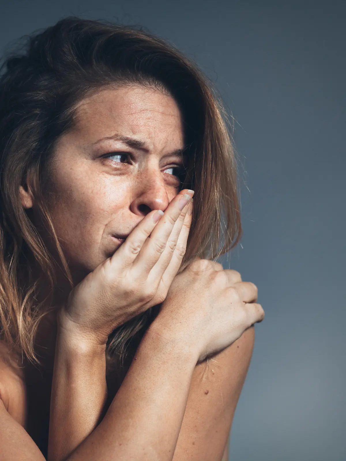 Frau in Kauerstellung weinend