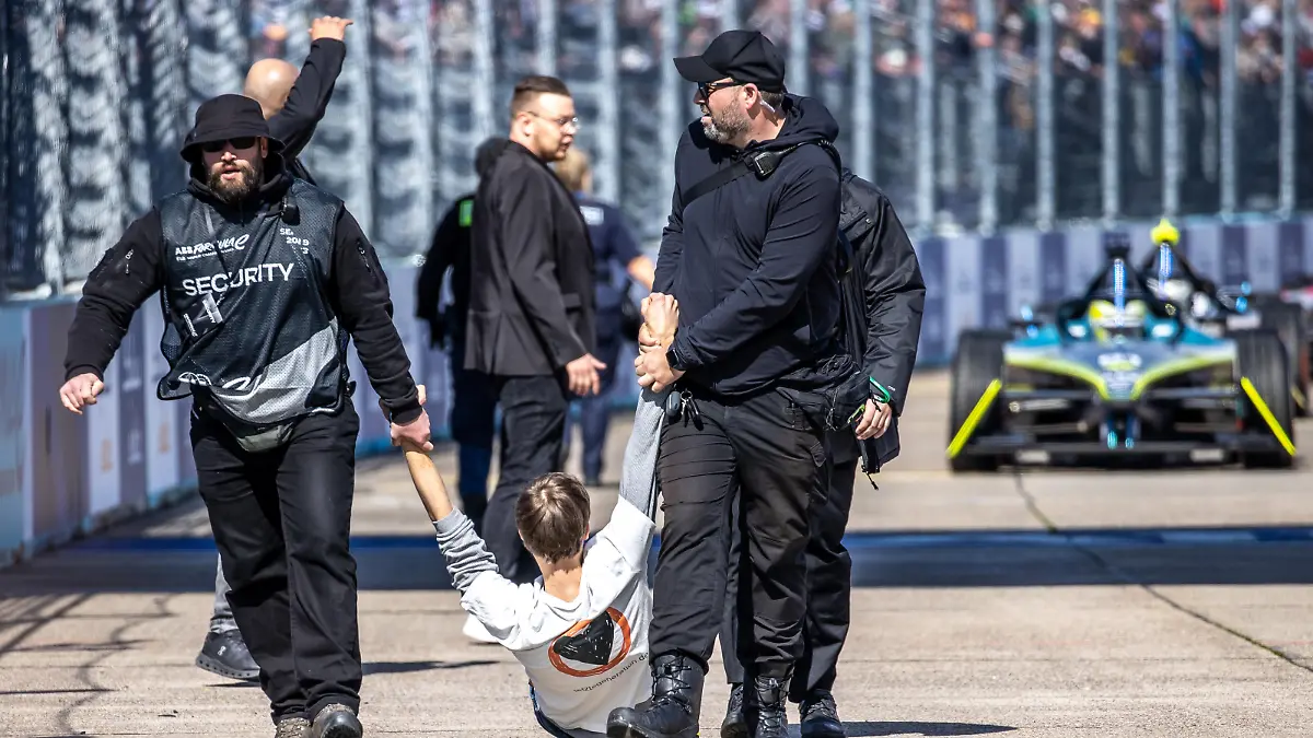 Motorsport: Formel-E: Berlin E-Prix am Tempelhofer Feld, Rennen: Sicherheitskräfte tragen einen Klimaaktivisten der letzten Generation von der Strecke.