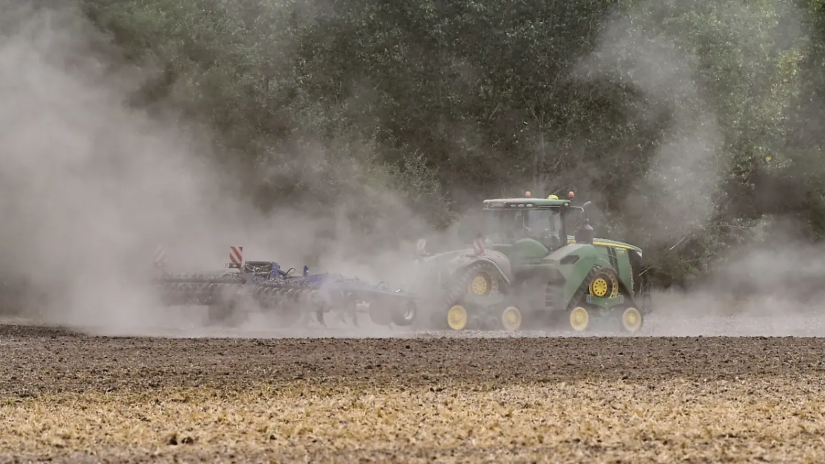 ARCHIV - 13.08.2022, Brandenburg, Manschnow: Ein Landwirt fährt mit einem Traktor und einer Egge über den trocken Ackerboden im Oderbruch in Ostbrandenburg. (zu dpa: «Kein Acker ohne Baum? Landwirte wollen die Erde vor Dürre schützen») Foto: Patrick Pleul/dpa +++ dpa-Bildfunk +++