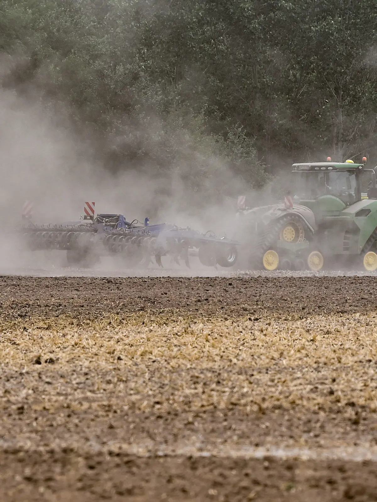 ARCHIV - 13.08.2022, Brandenburg, Manschnow: Ein Landwirt fährt mit einem Traktor und einer Egge über den trocken Ackerboden im Oderbruch in Ostbrandenburg. (zu dpa: «Kein Acker ohne Baum? Landwirte wollen die Erde vor Dürre schützen») Foto: Patrick Pleul/dpa +++ dpa-Bildfunk +++
