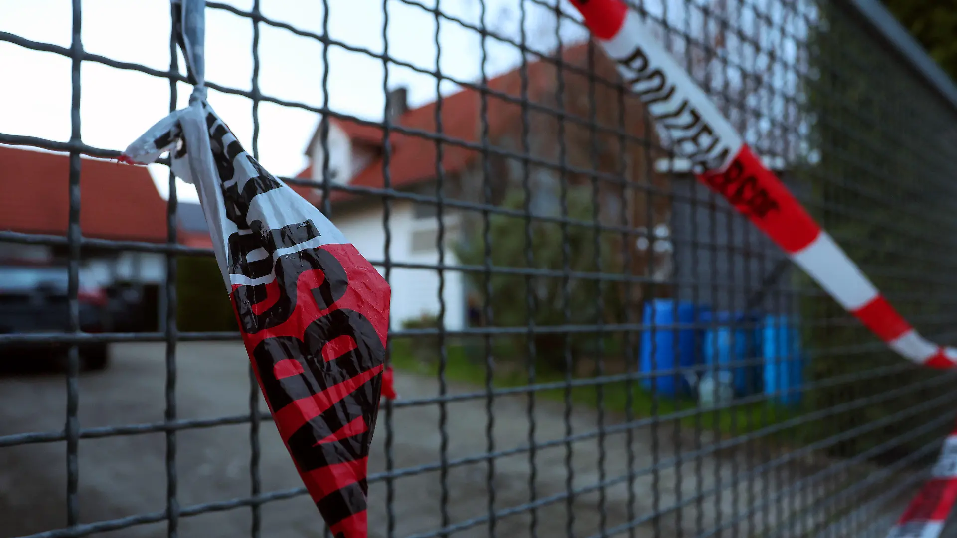 23.04.2023, Bayern, Altenstadt An Der Iller: Ein Absperrband der Polizei hängt am Abend am Hoftor eines Einfamilienhauses. Am Samstag wurden die Leichen eines Ehepaars in dem Haus entdeckt. Die Polizei geht davon aus, das die beiden getötet wurden. Foto: Karl-Josef Hildenbrand/dpa +++ dpa-Bildfunk +++