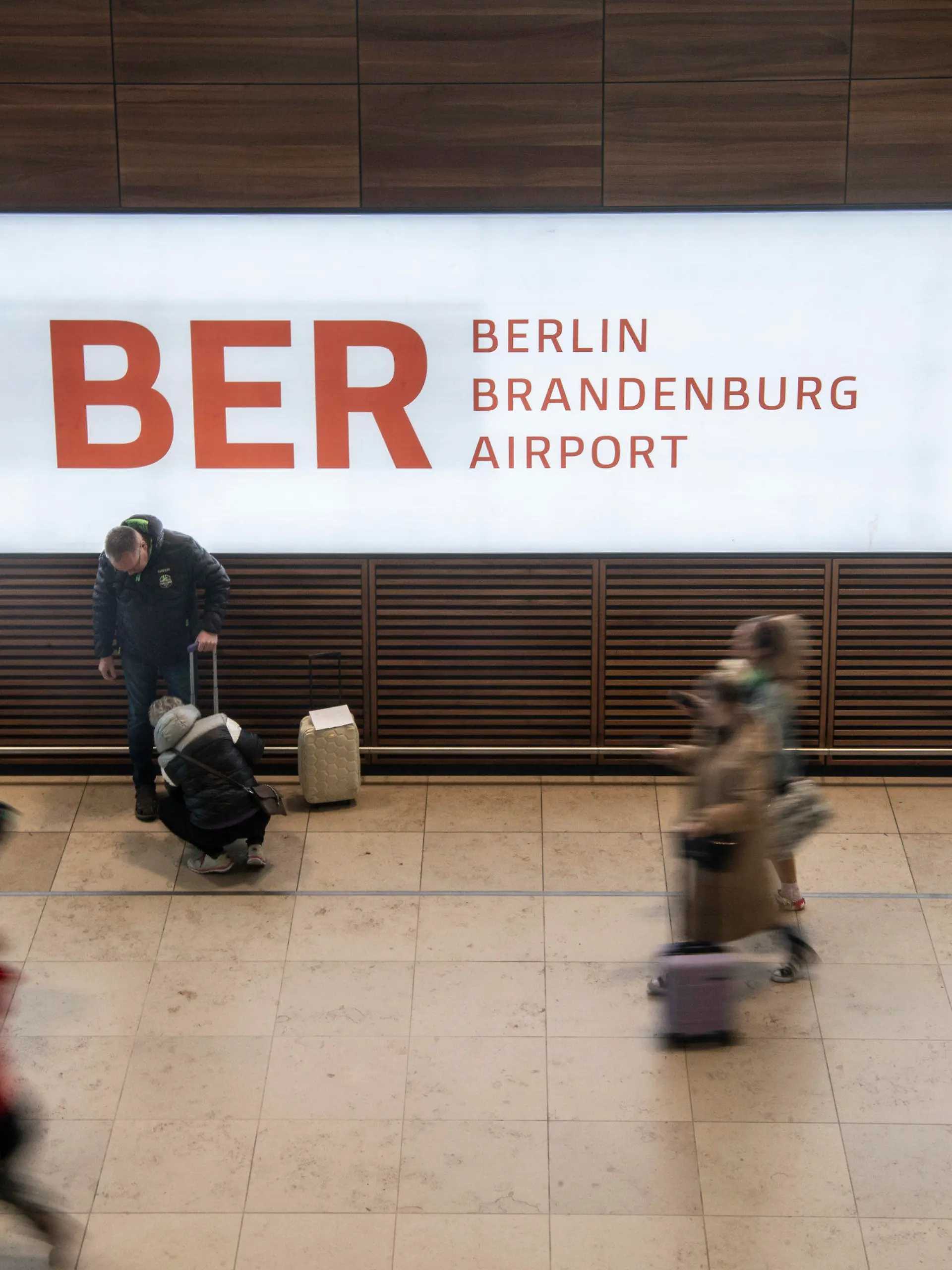 27.03.2023, Brandenburg, Schönefeld: Reisende gehen während des bundesweiten Warnstreiks im Bahn- und Luftverkehr durch das Terminal im Flughafen BER. Dort mussten nur wenige Flüge gestrichen werden. Mit einem großangelegten bundesweiten Warnstreik haben die Gewerkschaften EVG und Verdi am Montag weite Teile des öffentlichen Verkehrs lahmgelegt. Foto: Paul Zinken/dpa +++ dpa-Bildfunk +++