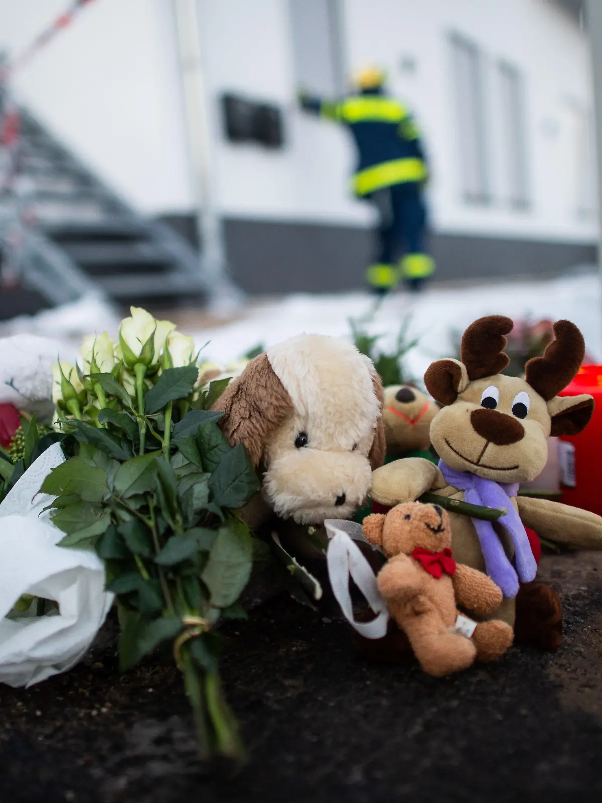 13.02.2021, Nordrhein-Westfalen, Radevormwald: Kuscheltiere und Kerzen liegen vor dem Haus in der Elberfelder Straße. Nach einem Brand am gestrigen Abend entdeckte die Feuerwehr fünf Leichen in dem Haus. Die Polizei schließt ein mögliches Kapitalverbrechen nicht aus. Foto: Jonas Güttler/dpa +++ dpa-Bildfunk +++