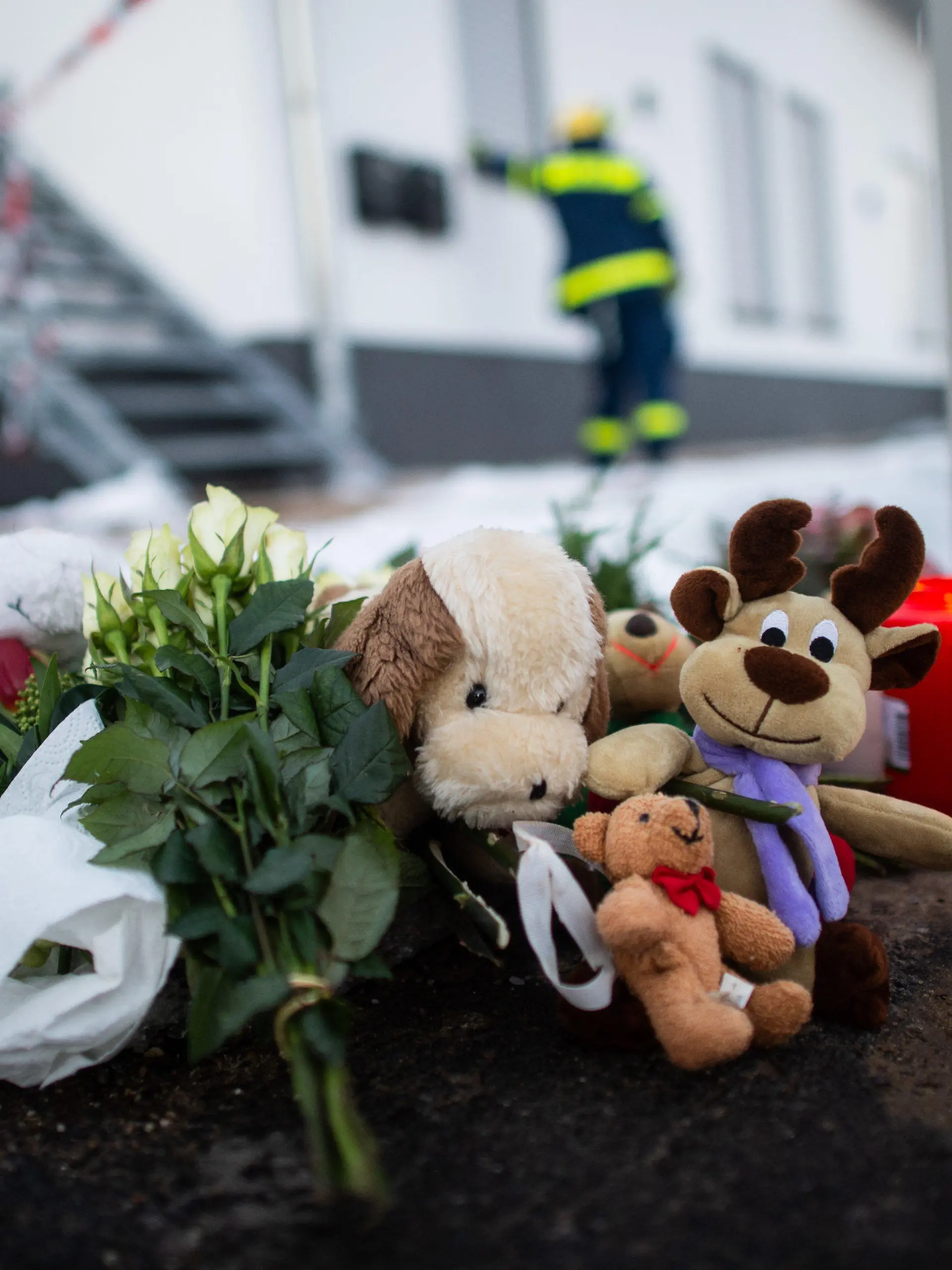 13.02.2021, Nordrhein-Westfalen, Radevormwald: Kuscheltiere und Kerzen liegen vor dem Haus in der Elberfelder Straße. Nach einem Brand am gestrigen Abend entdeckte die Feuerwehr fünf Leichen in dem Haus. Die Polizei schließt ein mögliches Kapitalverbrechen nicht aus. Foto: Jonas Güttler/dpa +++ dpa-Bildfunk +++