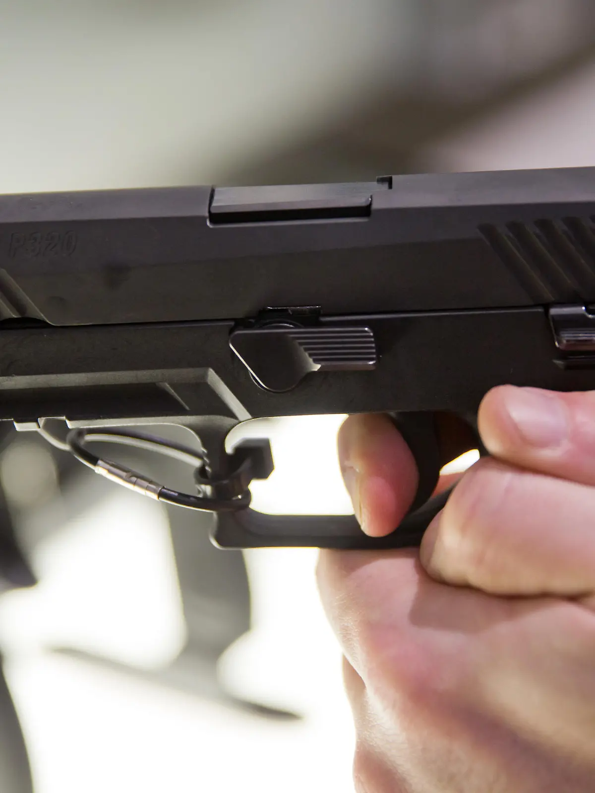 Ein Messebesucher hält eine Ausführung der Pistole vom Typ P320 des Waffenherstellers SIG Sauer GmbH & Co. KG am 05.03.2016 auf der Jagd- und Sportwaffenmesse IWA OutdoorClassics in Nürnberg (Bayern) am Stand des Unternehmens in der Hand. Foto: Daniel Karmann