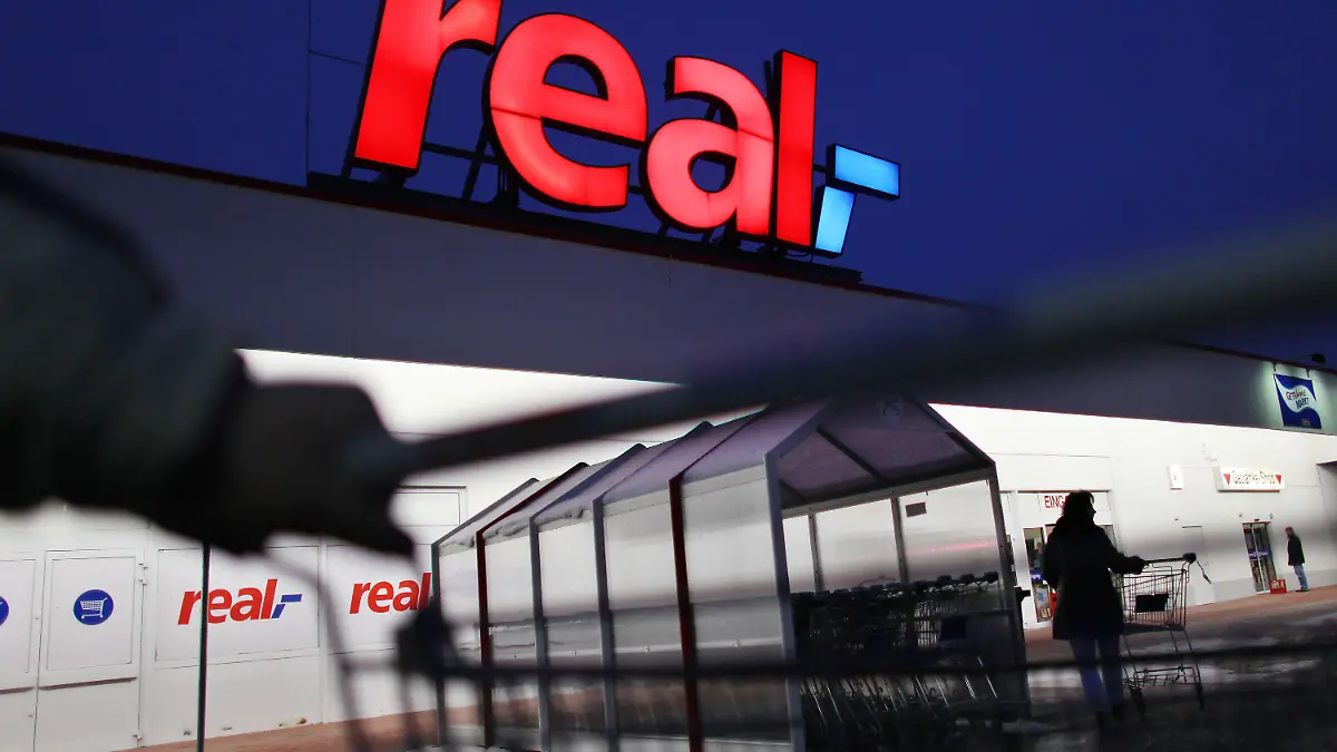 ARCHIV - Ein Mann schiebt seinen Einkaufswagen vor einem Real Supermarkt in Köln (Foto vom 12.01.2010). Wichtige Markenhersteller wie Dr. Oetker beliefern die Supermarktkette derzeit nicht. Es gibt Streit um die Konditionen. Wenn es ums Geld geht, wird im Handel öfter mit harten Bandagen gekämpft. Foto: Oliver Berg/dpa (zu dpa-KORR: "Lücken im Regal: Real hat Ärger mit Lieferanten" vom 17.07.2015) +++(c) dpa - Bildfunk+++