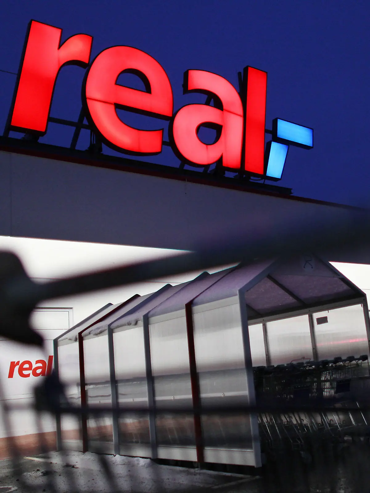 ARCHIV - Ein Mann schiebt seinen Einkaufswagen vor einem Real Supermarkt in Köln (Foto vom 12.01.2010). Wichtige Markenhersteller wie Dr. Oetker beliefern die Supermarktkette derzeit nicht. Es gibt Streit um die Konditionen. Wenn es ums Geld geht, wird im Handel öfter mit harten Bandagen gekämpft. Foto: Oliver Berg/dpa (zu dpa-KORR: "Lücken im Regal: Real hat Ärger mit Lieferanten" vom 17.07.2015) +++(c) dpa - Bildfunk+++